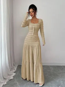 Detailed view of the elegant beige textured long-sleeve maxi dress showcasing fabric texture.