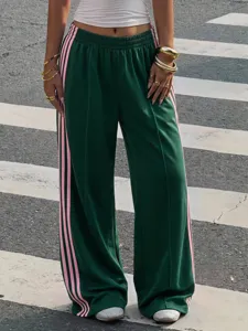 Detail shot of Y2K high-waist track pants with pink side stripes and comfortable drape.