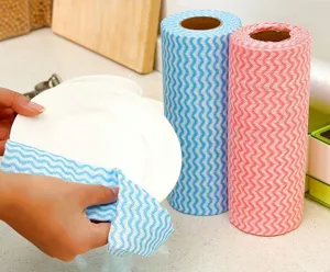 Gros plan de détail d'un chiffon non tissé essuyant une assiette, rouleau cuisine.
