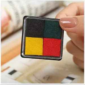 Gros plan d'un encrier de timbre compact à quatre couleurs en boîte transparente, disposition.