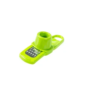 Green manual garlic grater kitchen gadget, hand-held ginger mincer tool main view display.