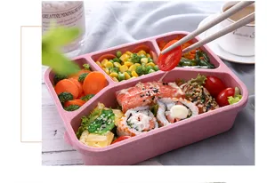 Close-up detail of pink wheat straw bento box with multi-compartment food layout.