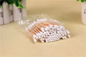 Detailed view of disposable wooden cotton buds with double tips in a clear bag for daily care.