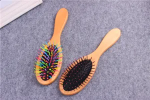 Wooden hair brush detail view, showing cushion comb design with colorful and standard bristles.