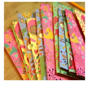 Cute cartoon pocket notebook set with colorful floral and animal illustrations on wood desk.