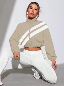 Close-up detail of khaki cropped track jacket featuring white diagonal stripes and collar.