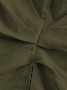 Detailed shot of olive green textured wrap shirt fabric showing pleated design close up