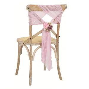 Detail view of pink chiffon chair sash with artificial roses for wedding party decor.