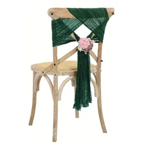 Green cheesecloth chair sash and pink rose flower decoration detail for wedding party decor.