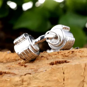 Close-up view of stainless steel geometric dumbbell pendant, fitness gym necklace accessory.