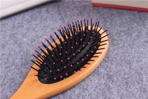 Detail view of a wooden hair brush with air cushion and massage pins for daily hair care.