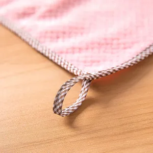 Close-up detail of coral fleece hanging dish cloth featuring a plaid loop and fine edge.