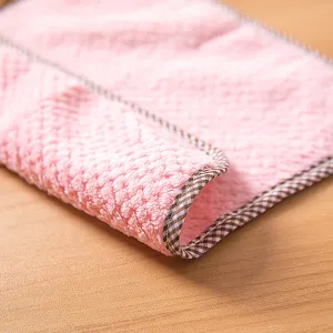 Coral fleece kitchen cleaning cloth close-up, soft pink absorbent dish rag with checked edge.