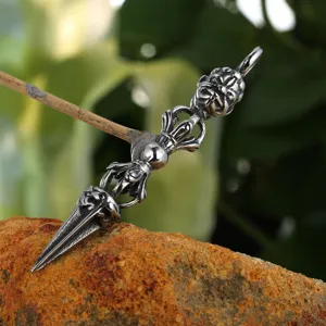 Detailed shot of retro metal vajra pestle pendant on rock, intricate carved texture design.