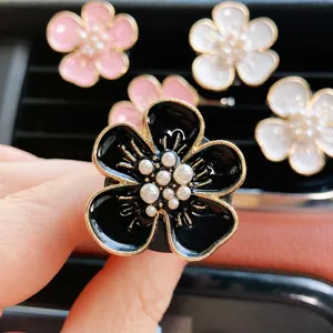 Floral car air vent clip pearl aromatherapy alloy five-petal flower auto decoration detail.