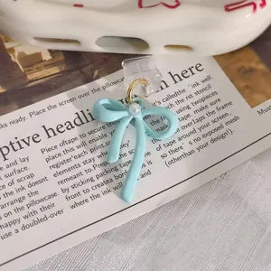 Cute light blue bow phone dust plug charm with pearl detail, trendy mobile accessory.