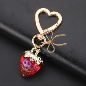 Mignon porte-clés fraise en cristal avec fermoir cœur, charm de sac élégant et scintillant.
