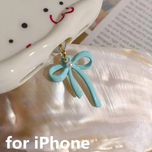 Detailed view of cute light blue bow phone dust plug pendant for iPhone charming accessory.