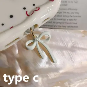 Close-up detail of Type-C phone dust plug featuring an elegant solid white bow and pearl pendant.