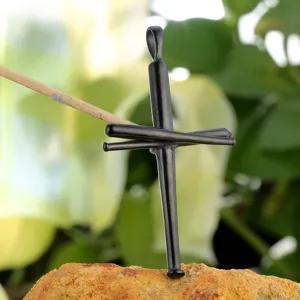Detailed closeup of a black stainless steel cross pendant styled like miniature baseball bats.
