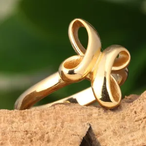 Gold titanium steel ring detail, artistic cross loop design, smooth polished high-end finish.
