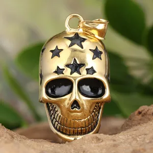 Nahaufnahme Detail des goldenen Totenkopf Anhängers mit schwarzen Emaille Sternen Textur.