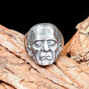 Close-up detail of stainless steel punk monster face ring for men with vintage rustic finish.