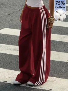 Detail shot of wide leg sweatpants featuring classic side stripes and loose casual fit.