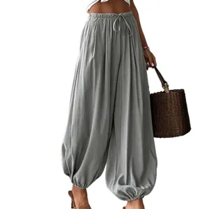Détail de pantalon sarouel lanterne gris à cordon, taille élastique et bas resserrés.