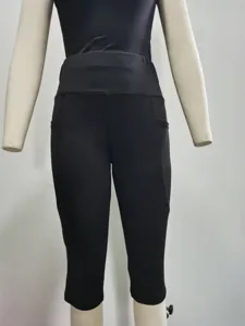Detail view of black women capri yoga pants with side pockets and high waist design.