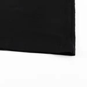Black skirt hem detail close up, smooth solid fabric texture, minimalist fashion style.