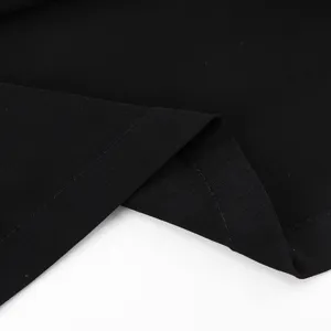 Close-up shot of smooth black fabric and neat stitching details of the long skirt.