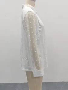Dettaglio laterale di camicetta bianca con maniche in tulle pois e colletto alto.