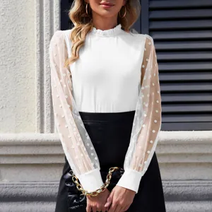 Vista dettagliata di elegante top bianco da donna con collo alto e maniche lunghe a pois.