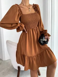 Detailed view of brown square neck long sleeve dress with smocked bodice and ruffled hem.