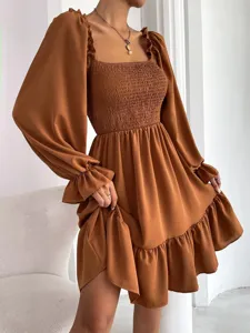 Chic brown long sleeve square neck dress featuring smocked bodice and ruffled hem details.