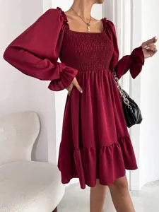 Burgundy long sleeve dress detail showcasing square neckline smocked bodice and ruffle hem.