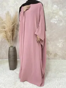 Detailed view of the elegant loose batwing sleeve maxi dress in soft pink tone with hijab.