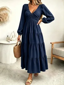 Detail view of the elegant navy blue long sleeve tiered maxi dress with V-neckline.