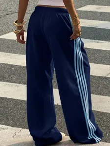 Casual wide-leg sweatpants detail showing contrast side stripes and comfortable fit.