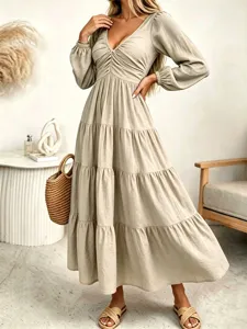 Detail view of the elegant beige V-neck long sleeve tiered maxi dress with ruched bodice.