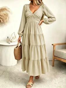 Detailed view of the elegant beige long sleeve tiered midi dress with stylish V-neckline.