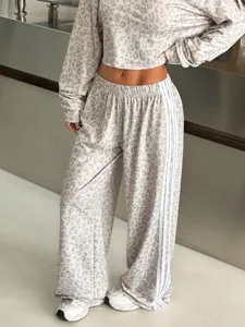 Detailed view of the stylish leopard print wide leg track pants with contrast side stripes.