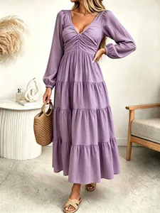 Closeup view of the purple tiered long sleeve dress with V-neck and ruched bust detailing.