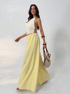 Detailed view of the elegant high-waisted drape wide-leg trousers paired with a chic ruched top.