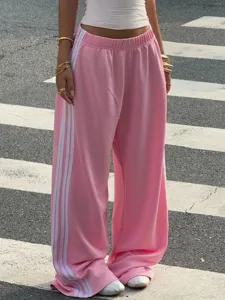 Pink wide-leg track pants with white side stripes, casual streetwear style, comfy fit.