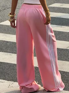 Pink wide-leg sweatpants with white side stripes, casual streetwear design for autumn comfort.