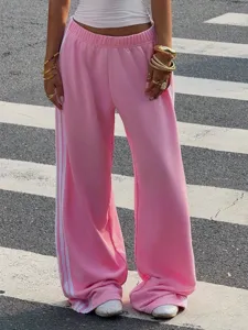 Pink loose wide-leg track pants featuring classic white side stripes for a chic street style look.