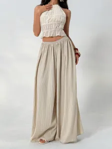 Detail shot of pleated wide-leg trousers showcasing texture, drape, and comfortable high waist.