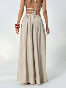 Back view detail of women's pleated wide-leg pants showing high waist and draped fabric.